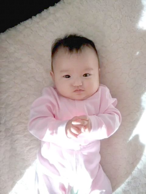 可愛的小寶貝躺在床上曬著太陽(yáng)